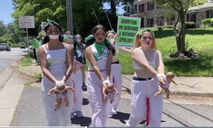 Pro-abortion activists in bloody outfits carry baby dolls outside Supreme Court Justice Amy Coney Barrett’s Virginia home